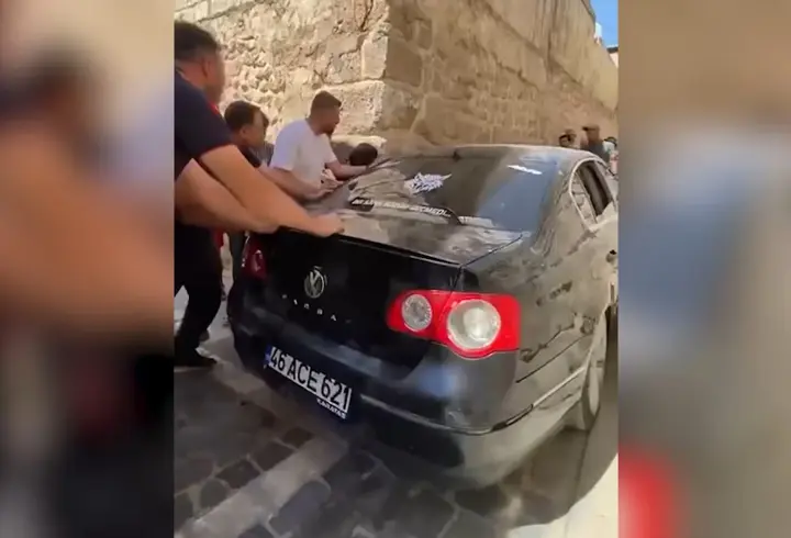 Dar sokakta sıkışan otomobil güçlükle çıkarıldı