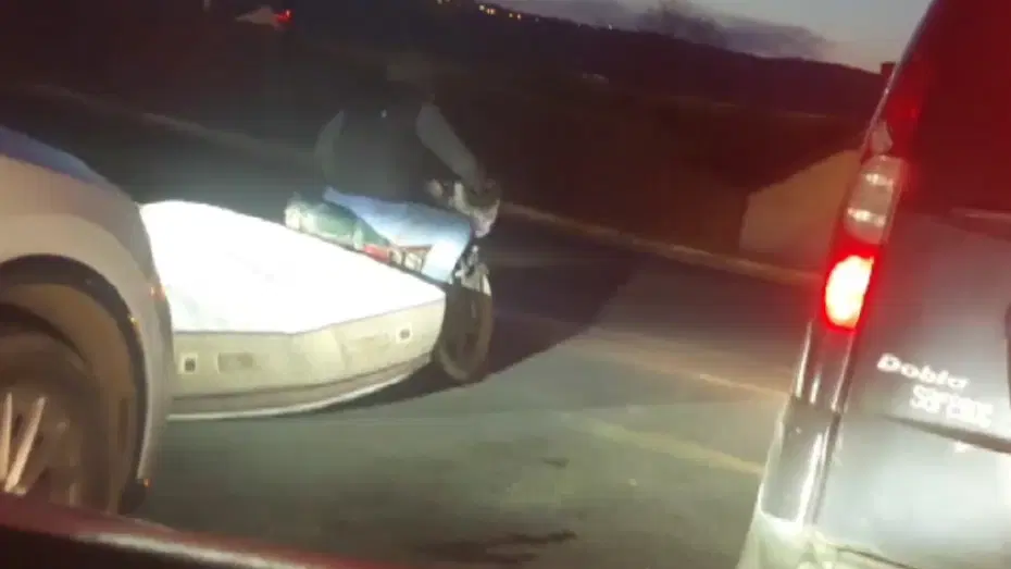Trafikte 'pes' dedirten görüntü: Motosikletle yatak taşıdı