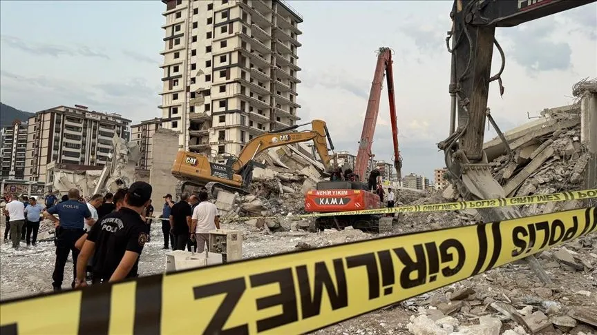 Kahramanmaraş'ta ağır hasarlı bina, yıkılırken iş makinesinin üzerine devrildi