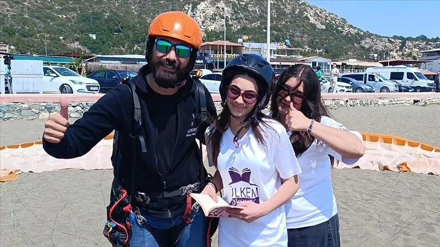 Hatay'da yamaç paraşütüyle atlayan öğrenciler gökyüzünde kitap okudu