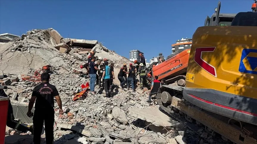 Kahramanmaraş'ta ağır hasarlı bina yıkılırken iş makinesinin üzerine devrildi