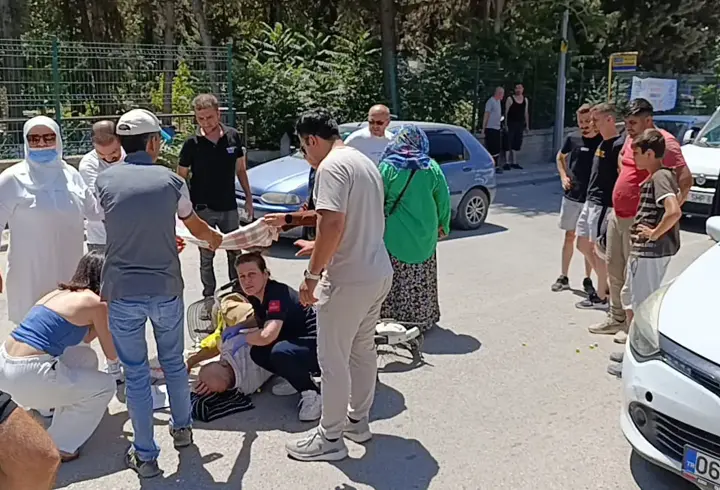 Otomobilin çarptığı bisikletliyi örtü tutarak güneşten korudular