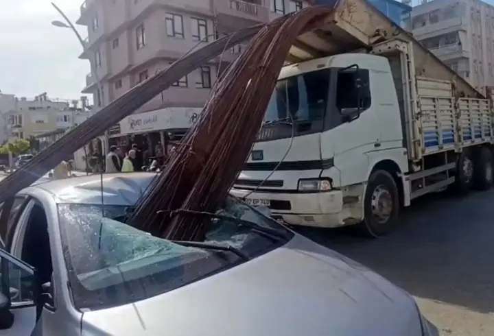 Kamyonun kasasından düşen inşaat demirleri, otomobilin tavanını deldi